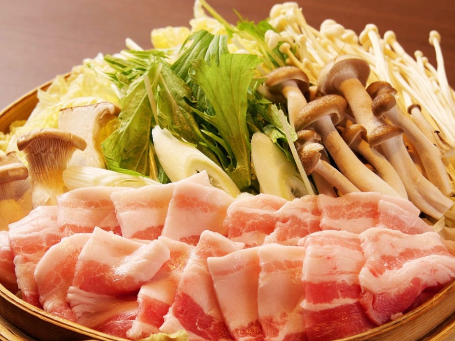蒸籠に並べた豚バラ肉ときのこ、野菜